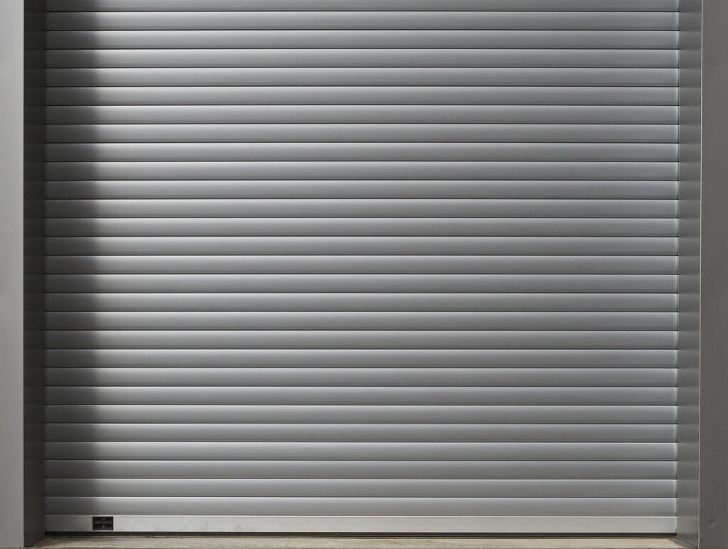 Closed silver industrial roll-up garage door.