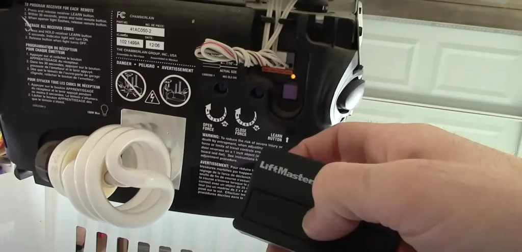 Programming a LiftMaster garage door opener remote with the learn button on the motor unit.